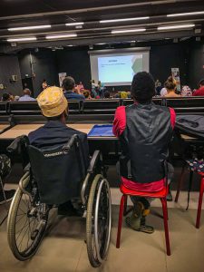 Une personne à mobilité réduite et son accompagnant au séminaire sur le travail et le handicap