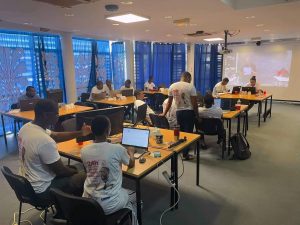 Des jeunes gens en train de participer à un concours de création de site internet dans une salle d'informatique.