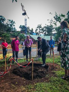 Homme plantant un jeune arbre entouré de personnes