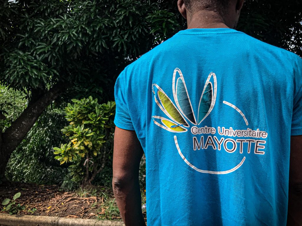 Homme de dos portant un T-shirt de l'université de Mayotte