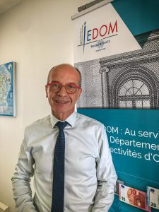 Homme avec des lunettes rouges posant en portait et souriant