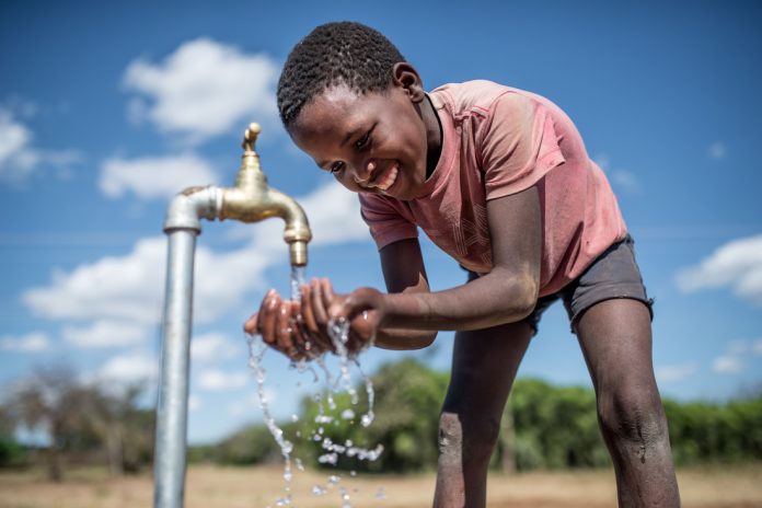 Enfant buvant de l'eau à une robinet